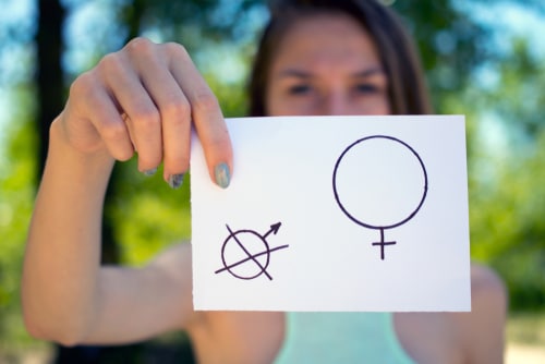 a piece of paper with a female and a male symbol in a womans hand