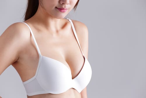 Closeup view of a young woman body chest breast with bra